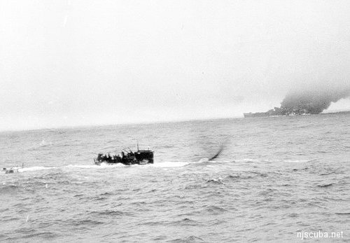 Pan Pennsylvania burns in the background as the stricken U-550 surfaces